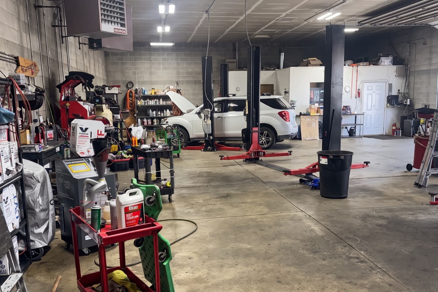 The shop floor at Missoula Automotive & Transmission, with two-post lifts, tool carts and an SUV in the back bay